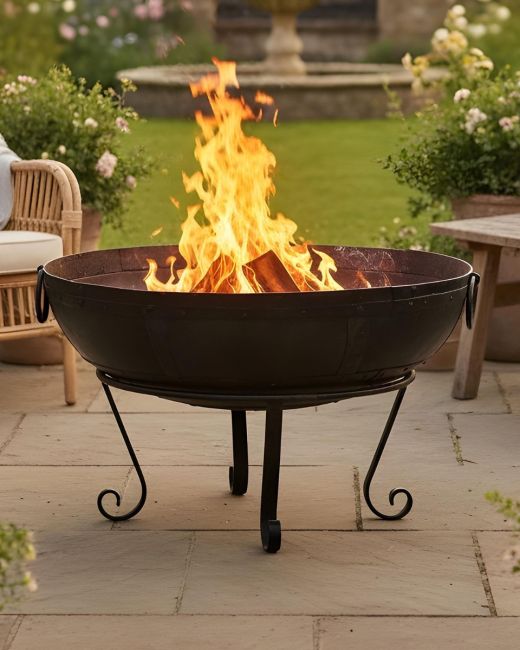 Digital Illustration of the 90cm Version of the Kadai Fire Bowl Fully Lit in Front of a Garden Lawn