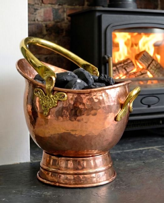 The 41cm"Windsor" Coal Bucket in a Copper Effect Finish Displayed on a Black Stone Fireplace - Digital Illustration