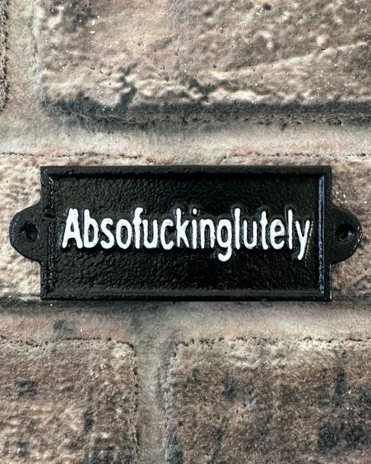 "Absofuckinglutely" Traditional Cast Iron Wall Sign mounted on a brick wall