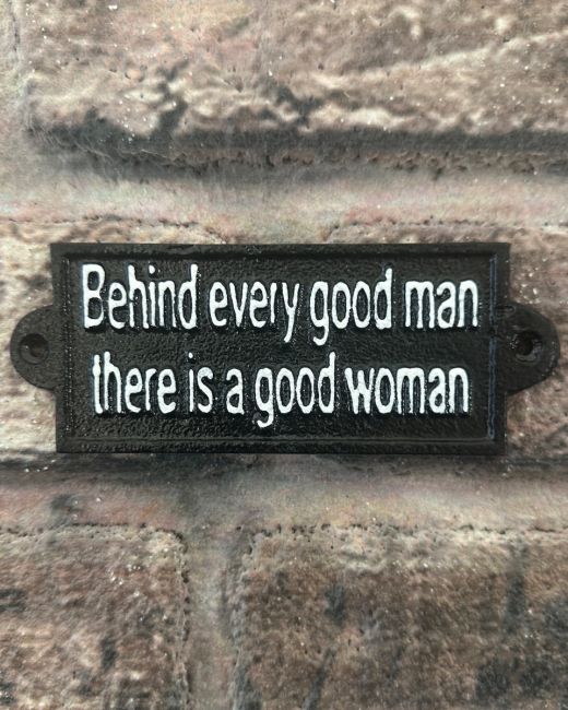 "Behind Every Good Man there is a Good Woman" Traditional Cast Iron Wall Sign mounted on a brick wall