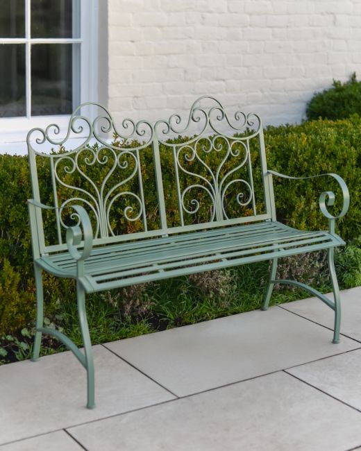 "Belvedere" Wrought Iron Garden Bench in front of hedge