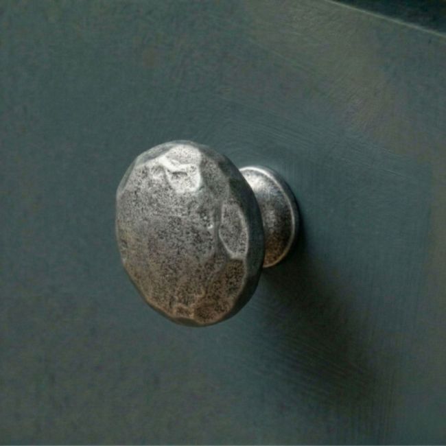 A 38mm Hammered Cast Iron Cabinet Knob Mounted on a Contemporary Blue Kitchen Cupboard - Digital Illustration 