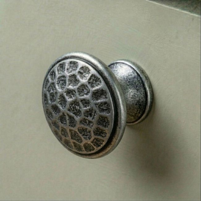 A 40mm Hammered Pewter Cabinet Knob Mounted on a Contemporary Sage Green Kitchen Cabinet - Digital Illustration