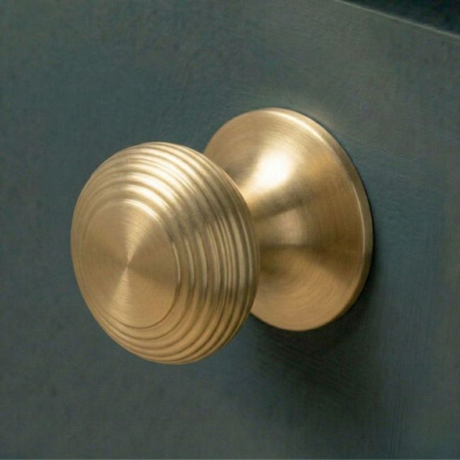 A 40mm Individual Satin Brass Beehive Cabinet Knob Fitted to a Blue Kitchen Cabinet - Digital Illustration 