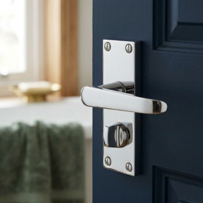 The Polished Chrome Victorian Straight Bathroom Door Handles - Lever Lock Pair with Thumb Turn on a White Background