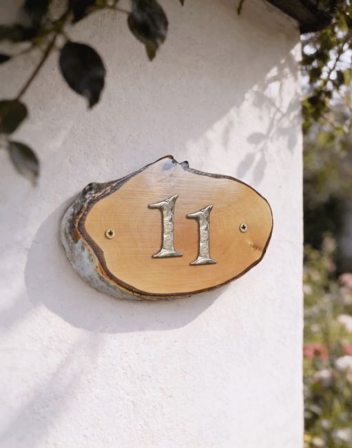 A Number 11 Natural Hard Wood Rustic House Number Sign Mounted on a Sunny White Cottage Wall - Digital Illustration A Number 11 Natural Hard Wood Rustic House Number Sign Mounted on a Sunny White Cottage Wall - Digital Illustration