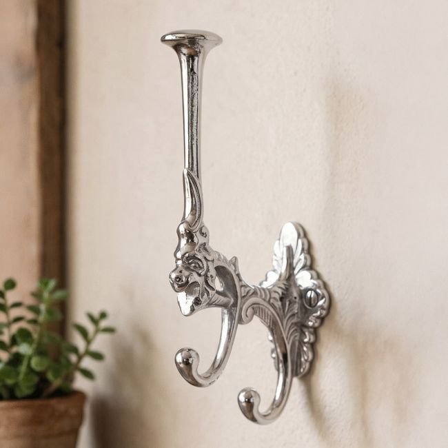 A Single Bright Chrome Art Deco Styled 3 Prong Hat and Coat Hook on a Textured Interior Wall - Digital Illustration A Single Bright Chrome Art Deco Styled 3 Prong Hat and Coat Hook on a Textured Interior Wall - Digital Illustration