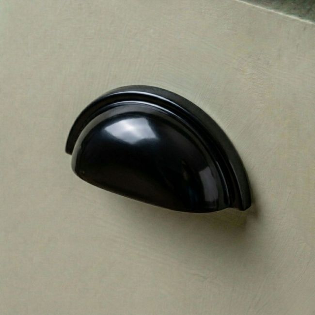 A Sleek Black Concealed Drawer Pull Mounted on a Sage Green Kitchen Drawer - Digital Illustration 