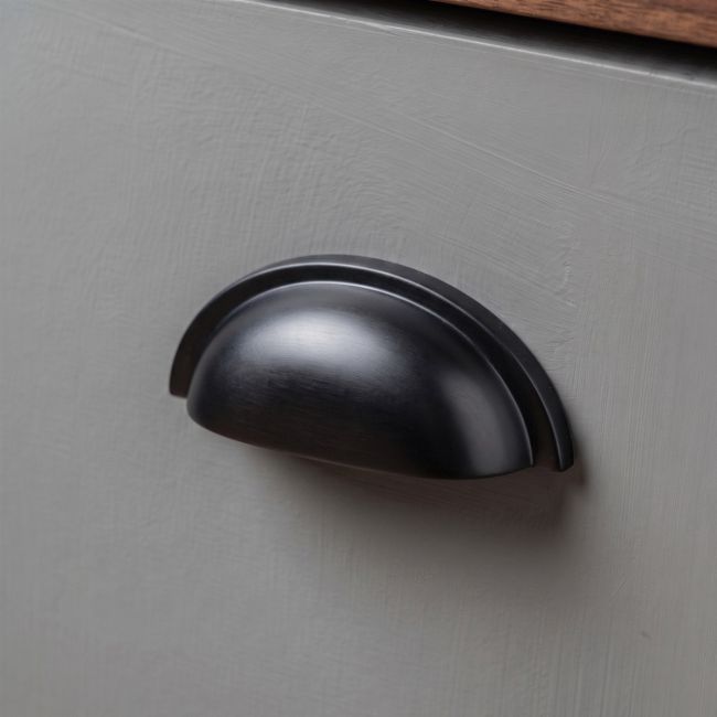 The Art Deco Concealed Cup Drawer Pull in Aged Bronze on a White Background 