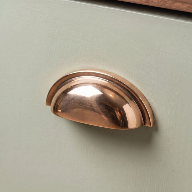 The Art Deco Concealed Cup Drawer Pull in Polished Bronze on a White Background 