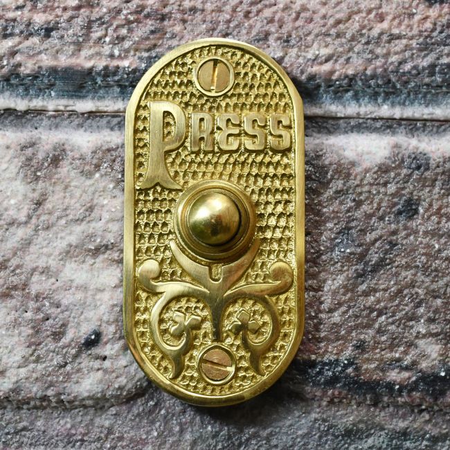 Vintage Polished Brass Bell Push on brick wall Vintage Polished Brass Bell Push on brick wall