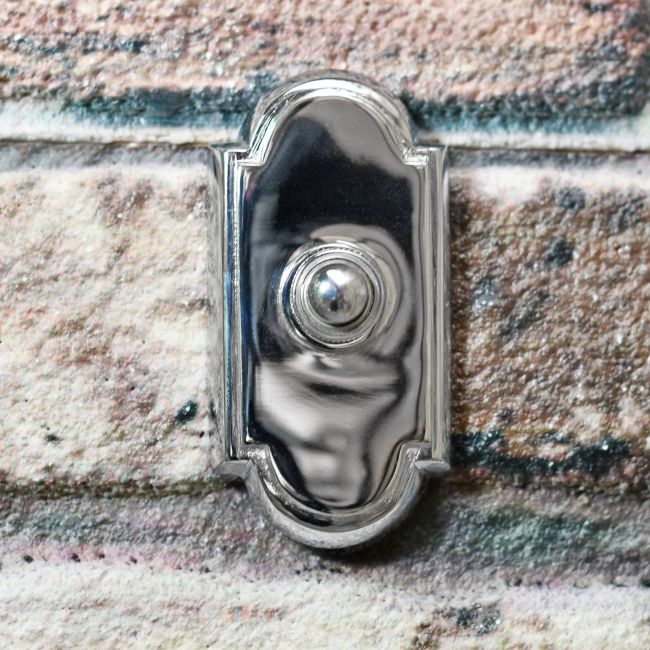 Arched Traditional Bright Chrome Door Bell on Brick Wall Arched Traditional Bright Chrome Door Bell on Brick Wall