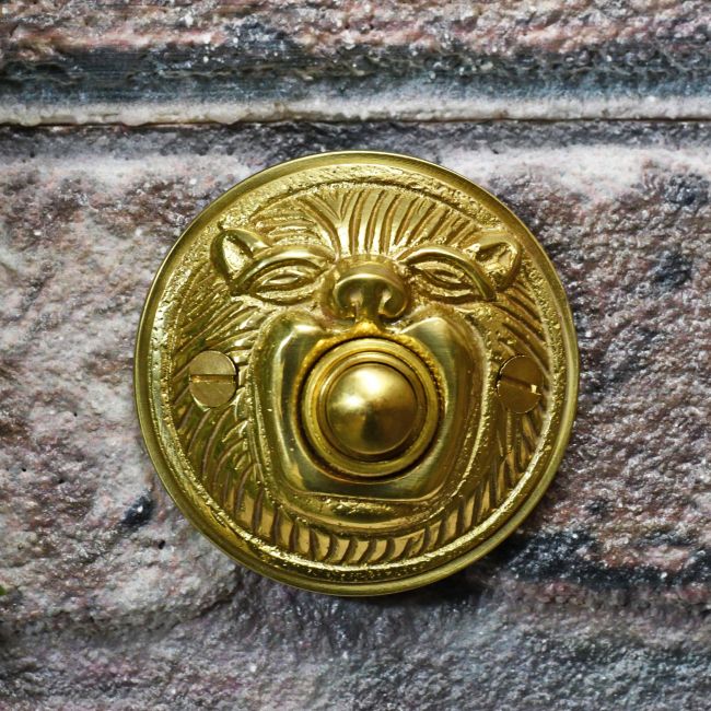 Polished brass bell push on brick wall Polished brass bell push on brick wall