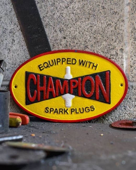 "Champion" Cast Iron Automobilia Reproduction Sign in Situ Next to a Blue Wall "Champion" Cast Iron Automobilia Reproduction Sign in Situ Next to a Blue Wall