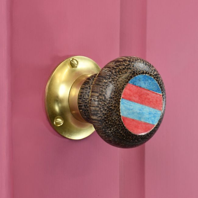 Blue & Red stripped door knob on Pink door with polished brass back plate