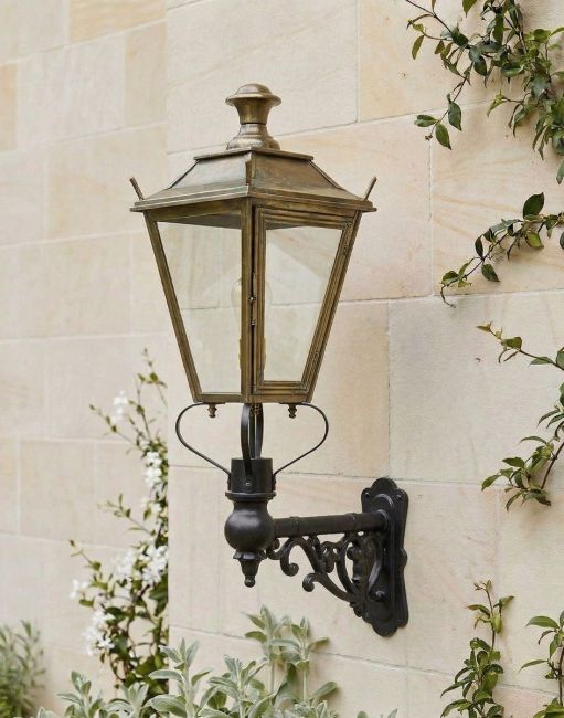 Digital Illustration of the 102 x 54cm Brass Dorchester Wall Lantern on an Ornate Bracket Mounted on a Traditional Sandstone Brick Wall