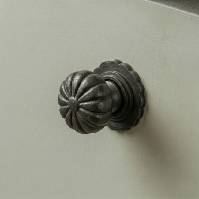 Digital Illustration of the 32mm Steel Beeswax Flower Cabinet Knob Mounted on a Sage Green Cupboard Door