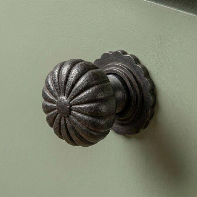Digital Illustration of the 38mm Steel Beeswax Flower Cabinet Knob Mounted on a Sage Green Cupboard