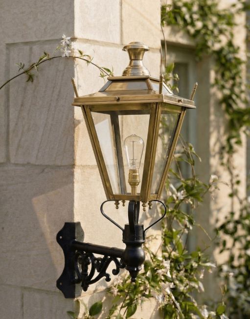 Digital Illustration of the 84 x 37cm Brass Dorchester Wall Lantern on a Corner Bracket Mounted on a Sandstone Brick Garden Wall