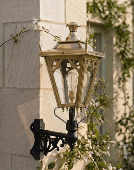 Digital Illustration of the 84 x 37cm Brass Gothic Wall Lantern on a Corner Bracket Mounted on a Sandstone Brick Sunny Garden Wall