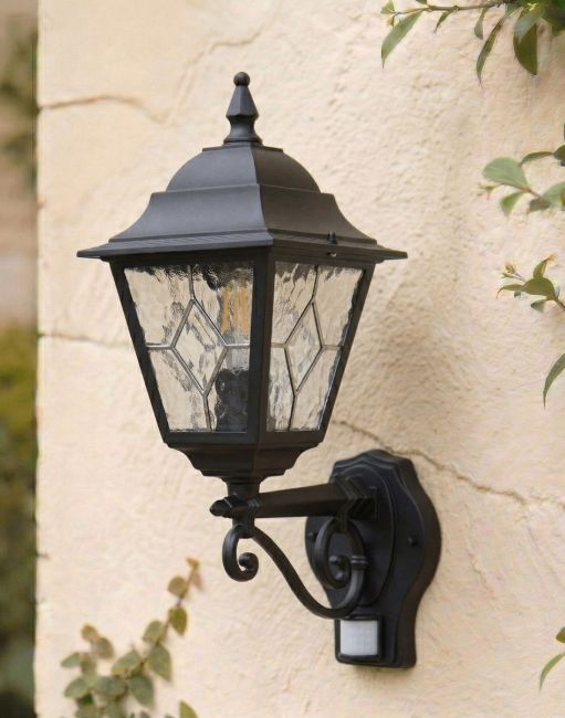 Digital Illustration of the Black "Sheringham" Traditional Wall Lantern with Built in PIR Sensor Mounted on a White Coloured Garden Wall