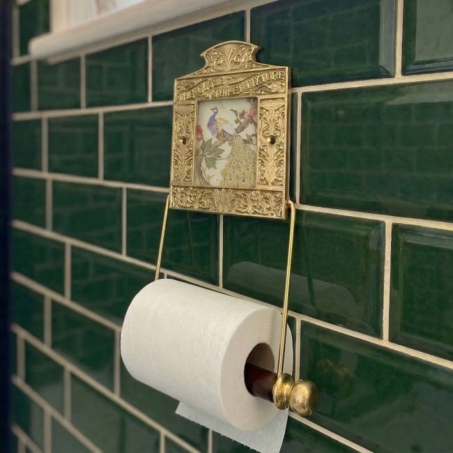 Digital Illustration of the Brass Version of the Globe Toilet Fixture Holding Toilet Roll Mounted on Green Bathroom Tiles