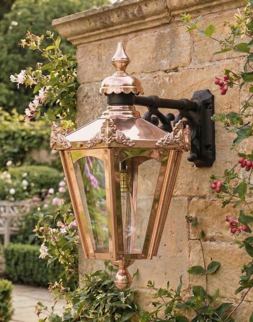 Digital Illustration of the Copper 60 x 34cm Hexagonal Wall Lantern Mounted on a Traditional Stone Garden Wall