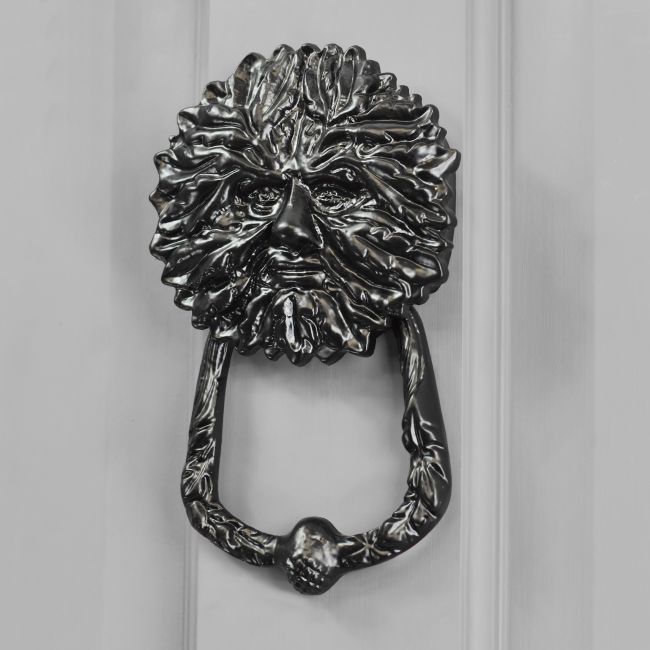 Green Man door knocker finished in black on grey door Green Man door knocker finished in black on grey door