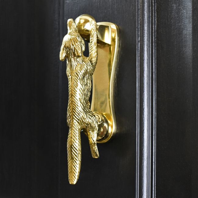 Polished Brass Running Fox Door knocker on black wood door Polished Brass Running Fox Door knocker on black wood door