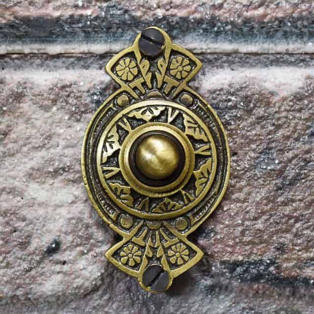 Antique Brass door bell on brick wall
