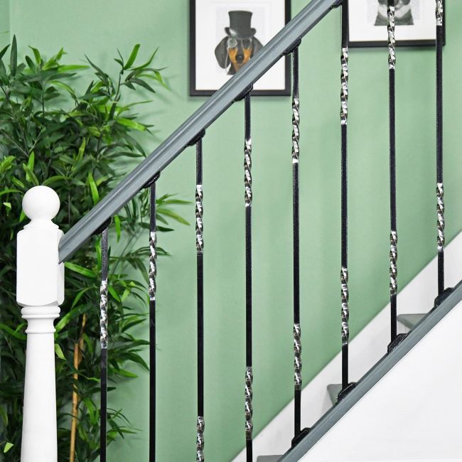 "Rabanne" Stainless Steel Stair Spindle in Use by a Green Wall "Rabanne" Stainless Steel Stair Spindle in Use by a Green Wall