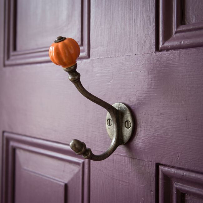The 125mm Ironmonger Acorn Orange Ceramic Coat Hook Shown on a. Purple Painted Door - Digital Illustration