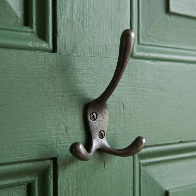 The Blacksmith Vintage Cast Iron Three-Prong Hall Hook - 100mm Mounted on a Green Door - Digital Illustration