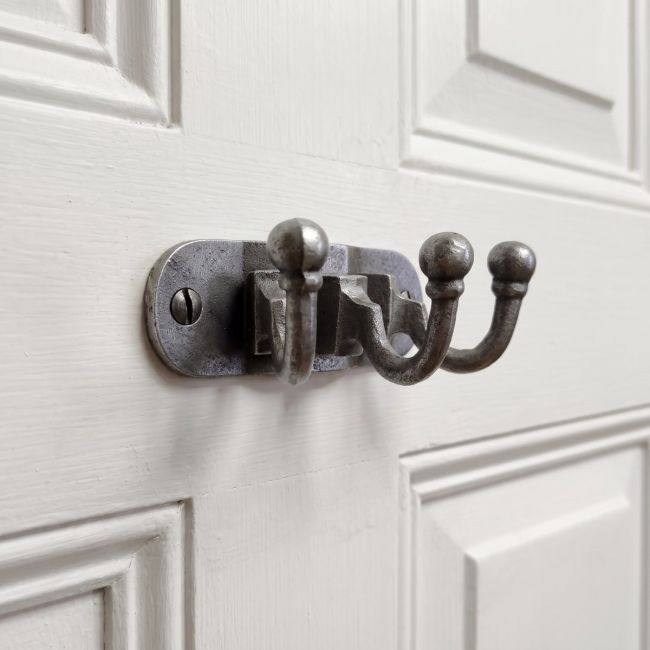 The Hawthorn Triple Coat Hook in Cast Antique Iron - 35 x 90mm on a White Door Shown Close up - Digital Illustration