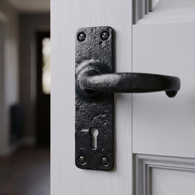 The Helmsdrock Foundry Blacksmith Style Lever Handle Shown on a Grey Door Close up in a Modern Home - Digital Illustration