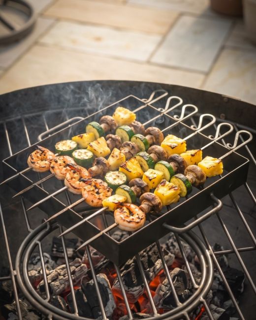 The Kadai Hand-Forged 6-Piece Skewer Set with Elevated Rack With made Kebabs being Flame Grilled - Digital Illustration