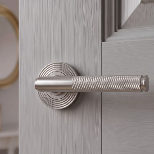 The Knurled Sprung Handle Set on a Beehive Rose in Satin Stainless Steel Shown at an Angle on a White Background