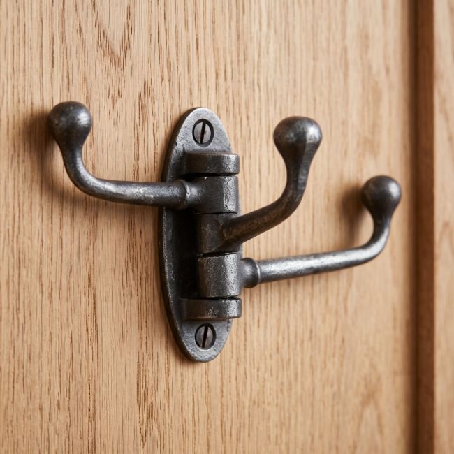 The Swivel Triple Arm Cast Iron Coat Hook 75mm x 100mm Mounted onto the Back of a Wooden Door - Digital Illustration