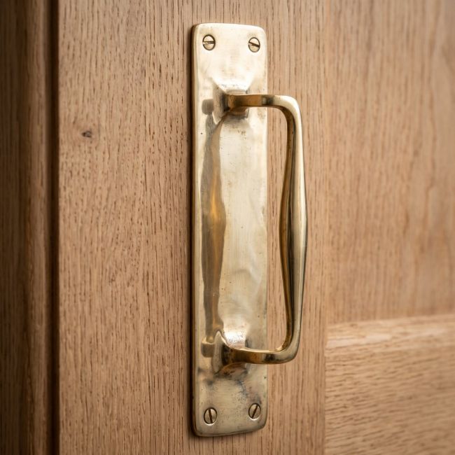 The Taproom Integral Plate Polished Brass Door Pull - 300mm Mounted on a Wooden Door - Digital Illustration