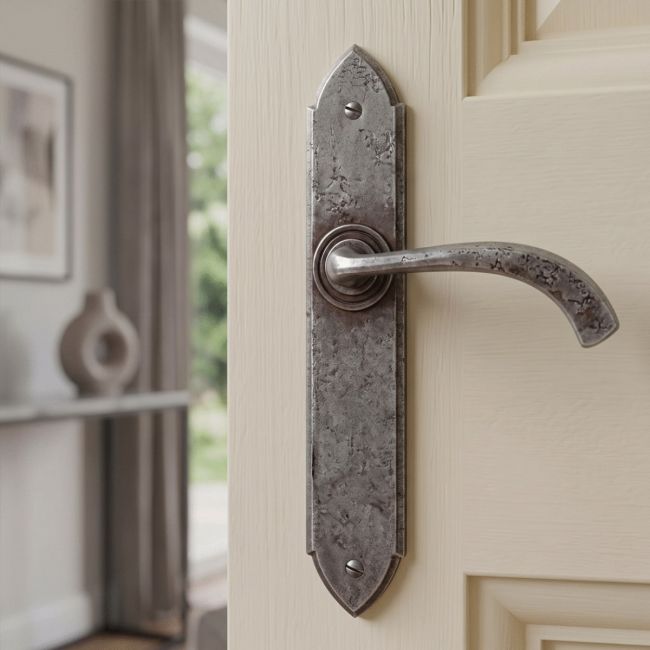 The Verona Curved Pewter Medieval Lever Handle Shown Mounted on a Cream Door in a Traditional Home - Digital Illustration