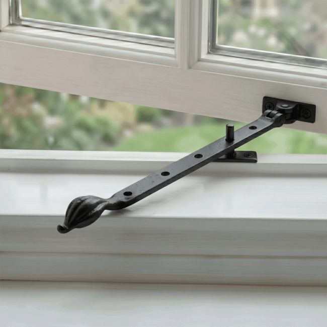The 12" Traditional Black Iron Window Casement Stay With Petal Shaped Handle Fitted on an Open White Window - Digital Illustration