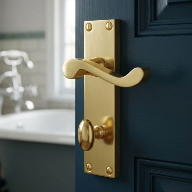 The Polished Brass Victorian Scroll Bathroom Door Handles - 150mm Lever Lock Pair on a white Background 