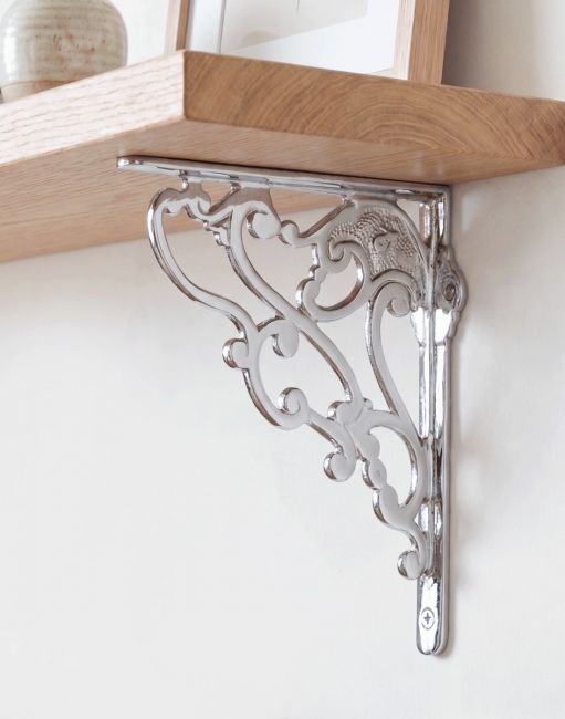 The 21 x 19cm Art Nouveau Bright Chrome Shelf bracket Mounted on a White Coloured Living Room Wall - Digital Illustration 