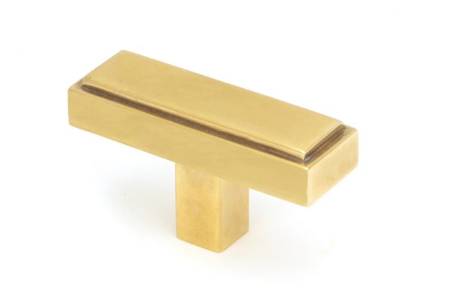 The "Emerson" Rectangular T-Bar Cabinet Pull Handle in an Aged Brass Finish on a White Background Shown at an Angle