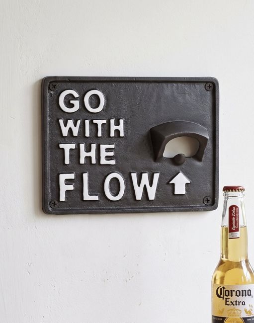 The "Go With The Flow" Iron Wall Mounted Bottle Opener Fixed to a White Painted Wall next to a Beer - Digital Illustration The "Go With The Flow" Iron Wall Mounted Bottle Opener Fixed to a White Painted Wall next to a Beer - Digital Illustration