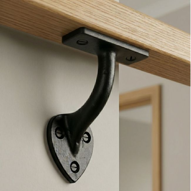 The "Mapleton" 3" Iron Handrail Bracket on a Wooden Bannister in a Modern Home - Digital Illustration The "Mapleton" 3" Iron Handrail Bracket on a Wooden Bannister in a Modern Home - Digital Illustration