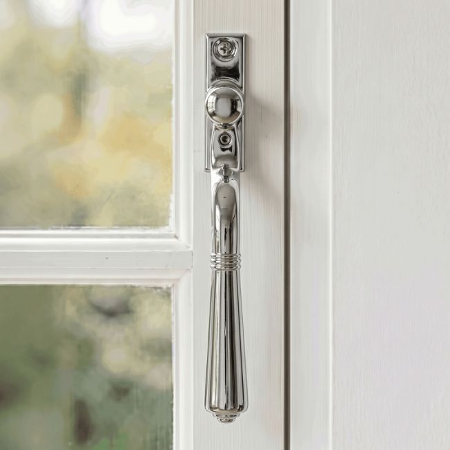 The "Regency" Polished Chrome Teardrop Espagnolette Window Fastener Fitted on a White Painted Window Frame - Digital Illustration