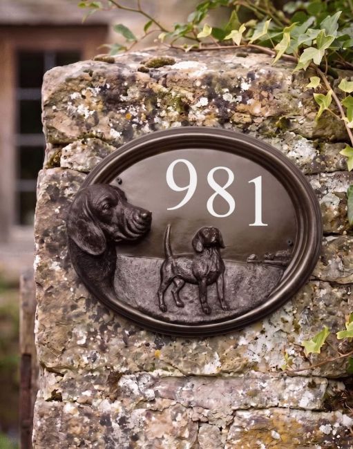 A Number 981 "Tucker" Beagle House Number Sign in a Bronze Finish Mounted on a Cream Coloured Cottage Wall - Digital Illustration A Number 981 "Tucker" Beagle House Number Sign in a Bronze Finish Mounted on a Cream Coloured Cottage Wall - Digital Illustration
