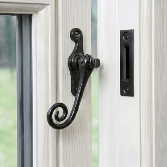 The "Wellford" Iron Casment Window Fastener Mounted on a Classic White Window Frame in a Country Home - Digital Illustration 