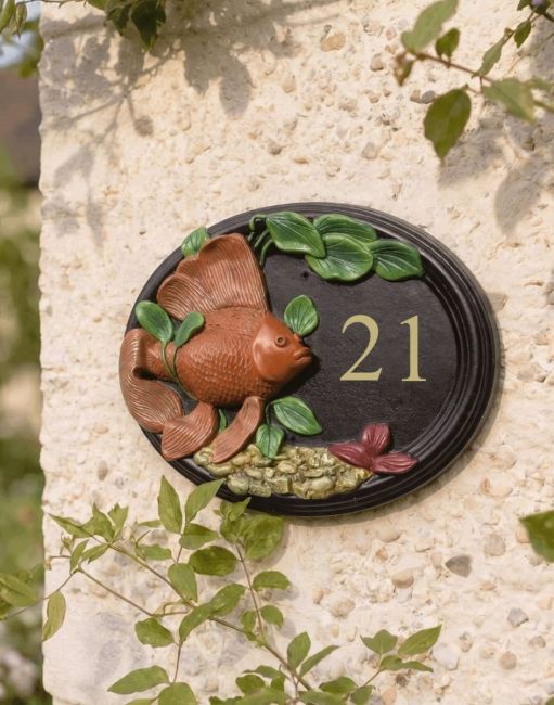 A Number 23 "Wellhurst Lakes" Hand Painted Goldfish House Sign Mounted on a sunny Cottage Garden Wall - Digital Illustration A Number 23 "Wellhurst Lakes" Hand Painted Goldfish House Sign Mounted on a sunny Cottage Garden Wall - Digital Illustration